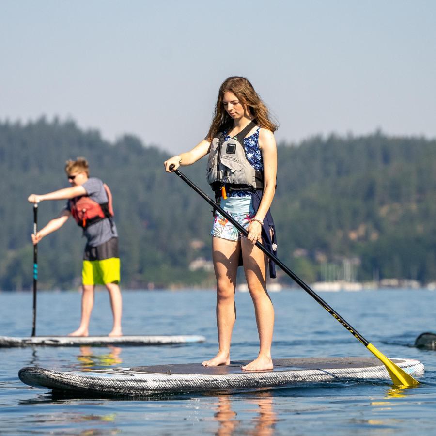 3 three people paddling boarding on the lake